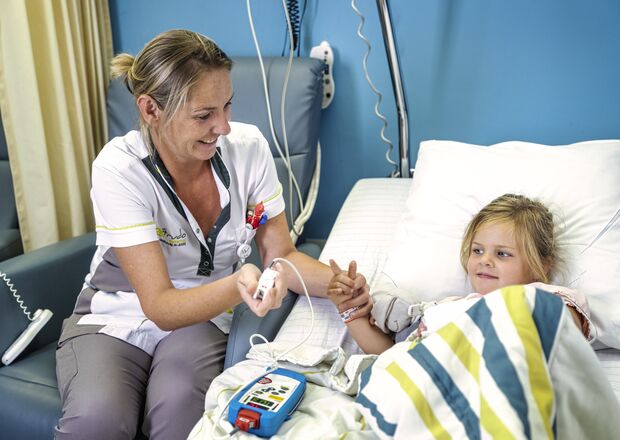 Kindje in ziekenhuisbed, verpleegkundige neemt parameters.