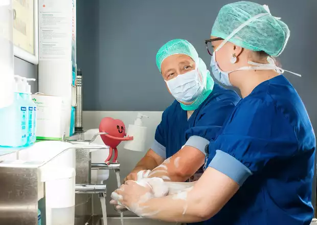 dr. Wim De Weerdt en verpleegkundige Annelien schrobben samen de handen 